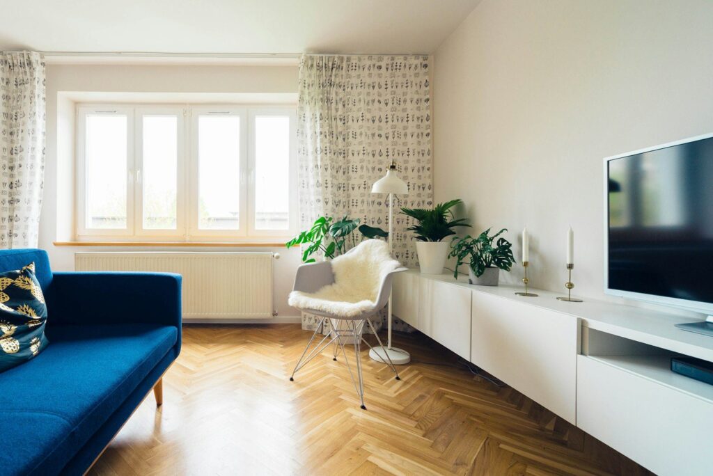 Heller Wohnraum mit Parkett und blauem Sofa
